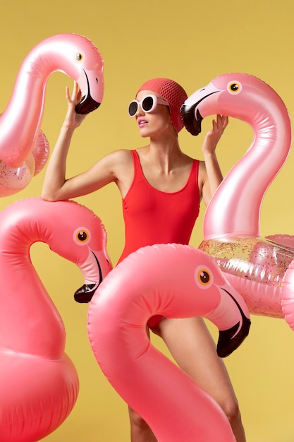 Junge Frau, die mit Flamingoschwimmring aufwirft