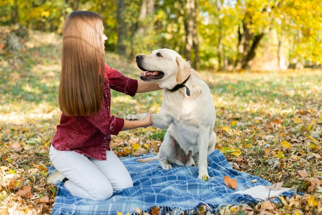 Junge Frau, die mit ihrem Hund spielt