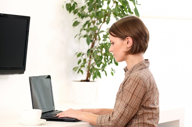 Junge Frau, die mit Laptop arbeitet