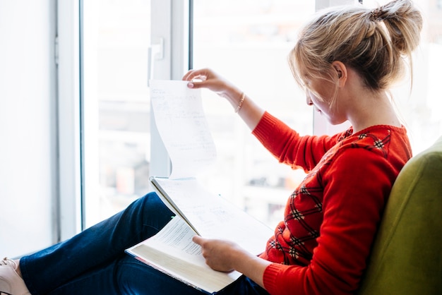 Junge Frau, die mit Notizbuch studiert