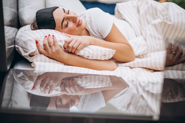 Junge Frau, die morgens im Bett stillsteht