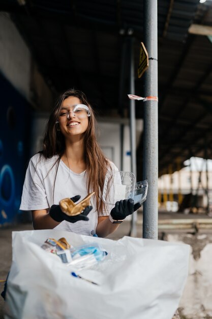 Junge Frau, die Müll sortiert. Konzept des Recyclings. Kein Verlust