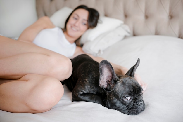 Junge Frau, die nahe bei ihrem Hund kühlt