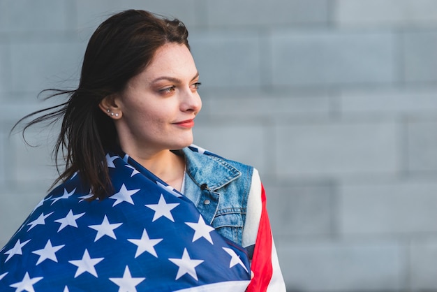 Kostenloses Foto junge frau, die oben in der amerikanischen flagge rollt