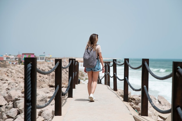 Junge Frau, die ohne Covid am Meer reist