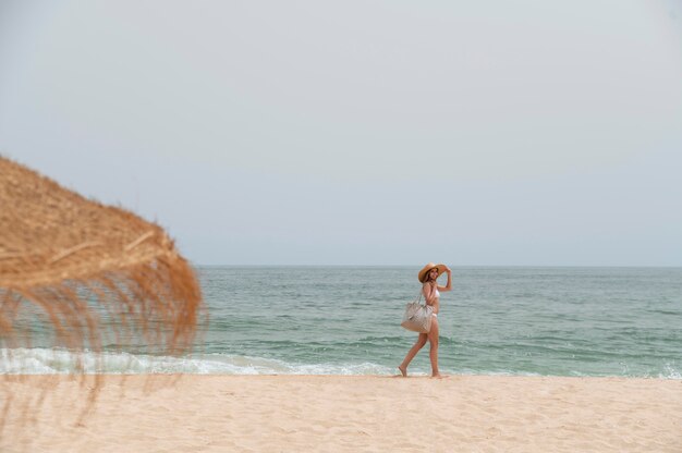 Junge Frau, die ohne Covid am Meer reist