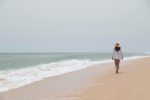 Junge Frau, die ohne Covid am Meer reist