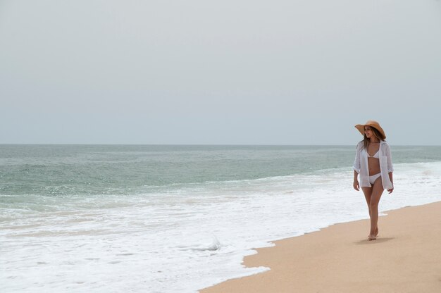 Junge Frau, die ohne Covid am Meer reist