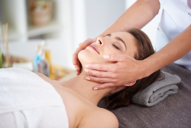 Junge Frau, die professionelle Gesichtsmassage erhält receiving