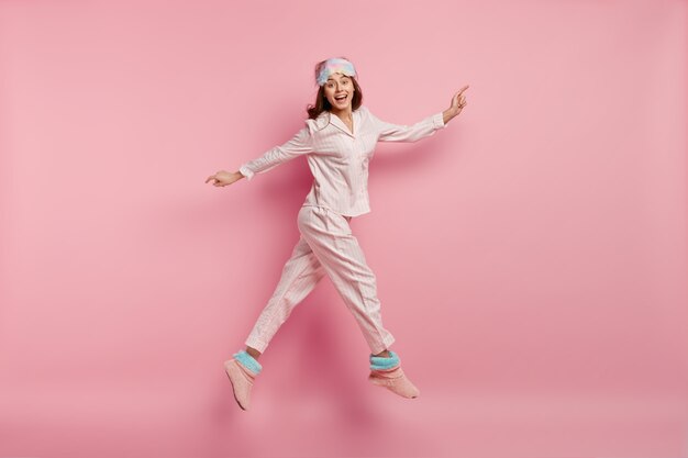 Junge Frau, die Pyjamas und Schlafmaske trägt
