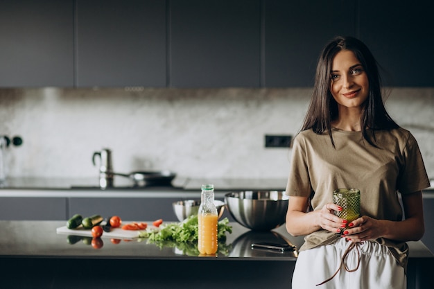 Junge Frau, die Saft zu Hause trinkt