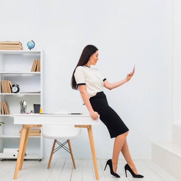 Junge frau, die selfie im büro nimmt