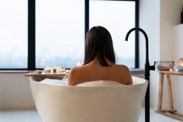 Kostenloses Foto junge frau, die sich in der badewanne beim baden entspannt