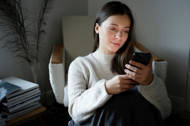 Junge Frau, die sich mit ihrem Smartphone ein Video anschaut