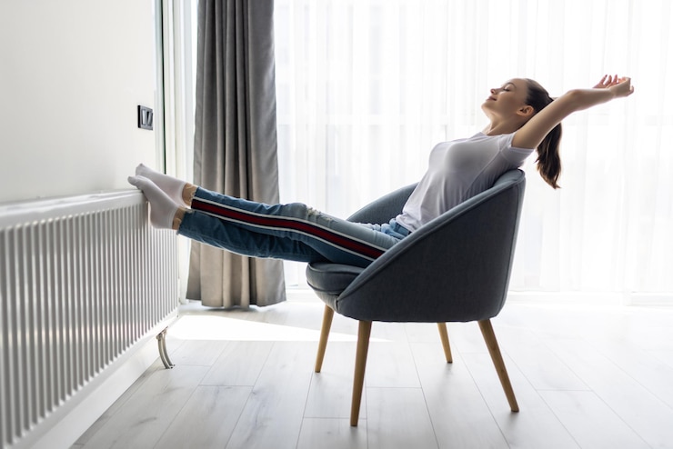 Kostenlose Foto junge frau, die sich zu hause im modernen stuhl entspannt