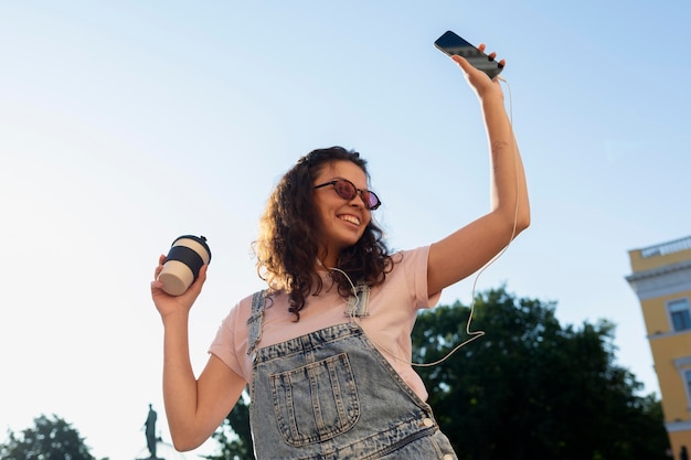 Kostenloses Foto junge frau, die spaß hat, während sie eine tasse kaffee hält