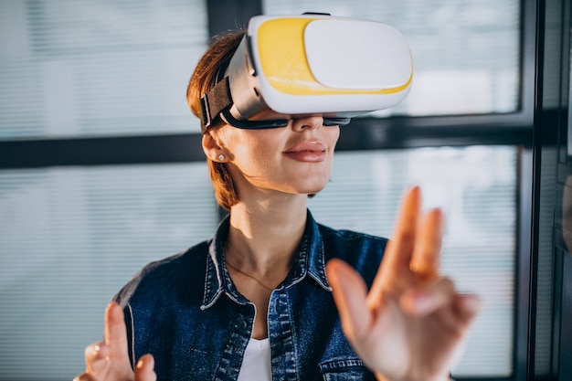 Junge Frau, die Spiel durch die VR-Gläser spielt