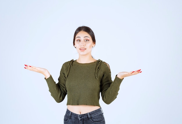 Junge Frau, die steht und ihre Hände zeigt, als ob etwas schief gelaufen wäre.