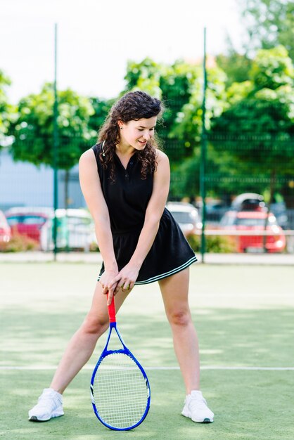 Junge Frau, die Tennis auf Gericht spielt