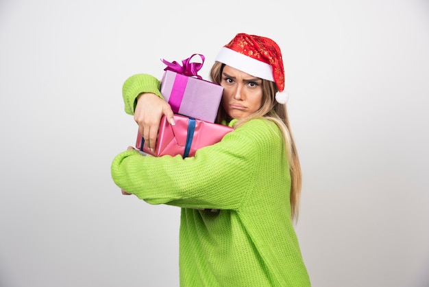 Kostenloses Foto junge frau, die viele festliche weihnachtsgeschenke hält