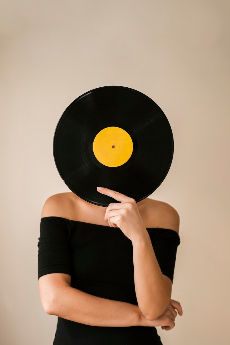 Kostenlose Foto junge frau, die vinylaufzeichnung über ihrem gesicht hält