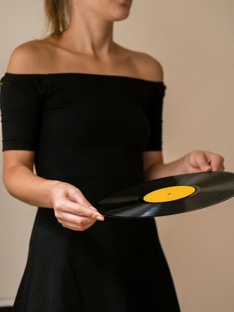 Kostenloses Foto junge frau, die vinylaufzeichnungsscheibe hält