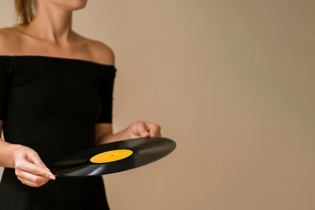 Junge Frau, die Vinylscheibe mit Kopieraum hält