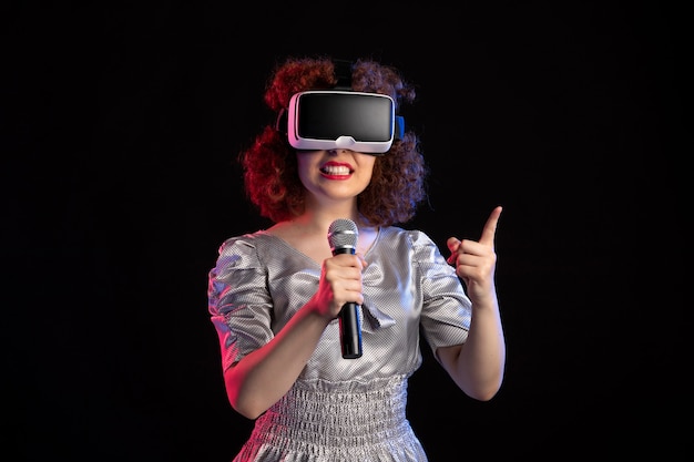 Junge Frau, die Virtual-Reality-Headset mit Mikrofon trägt