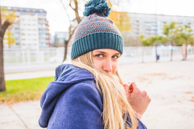 Junge Frau, die vom Herbstwind sich versteckt