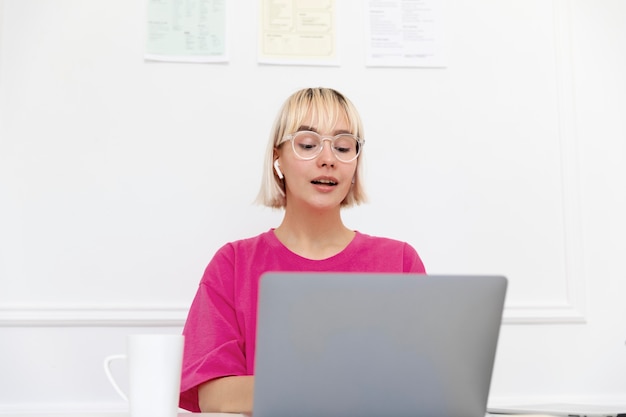 Kostenloses Foto junge frau, die von zu hause aus an ihrem laptop arbeitet