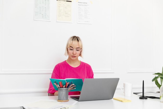 Kostenloses Foto junge frau, die von zu hause aus an ihrem laptop arbeitet