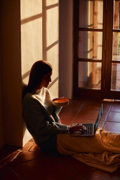 Junge Frau, die von zu Hause aus arbeitet