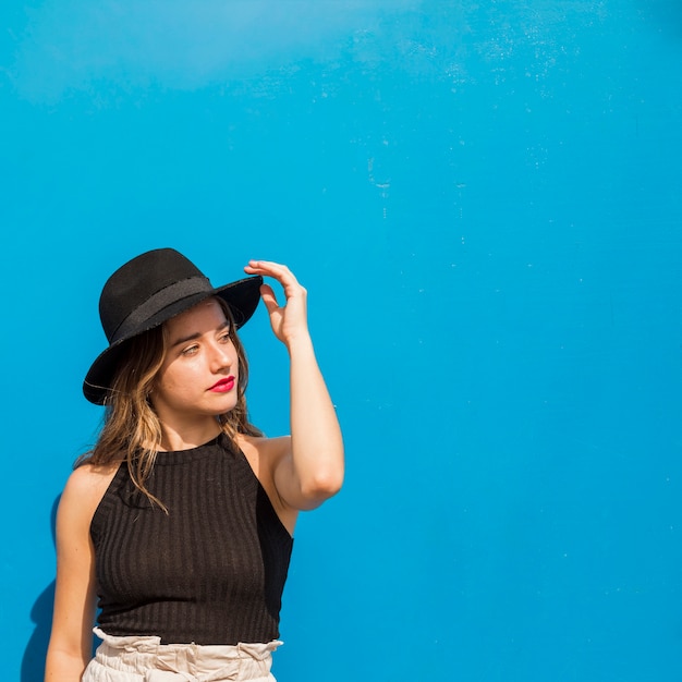 Kostenloses Foto junge frau, die vor blauem himmel aufwirft