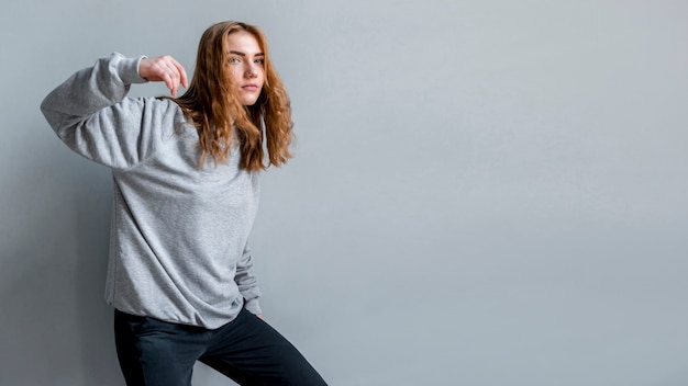 Kostenloses Foto junge frau, die vor grauer wand steht