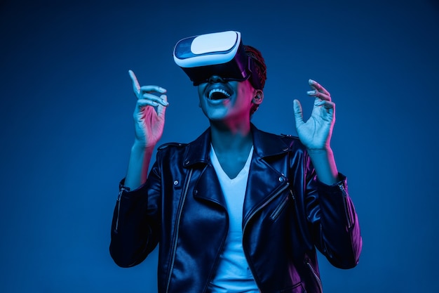 Junge Frau, die VR-Brille im Neonlicht verwendet