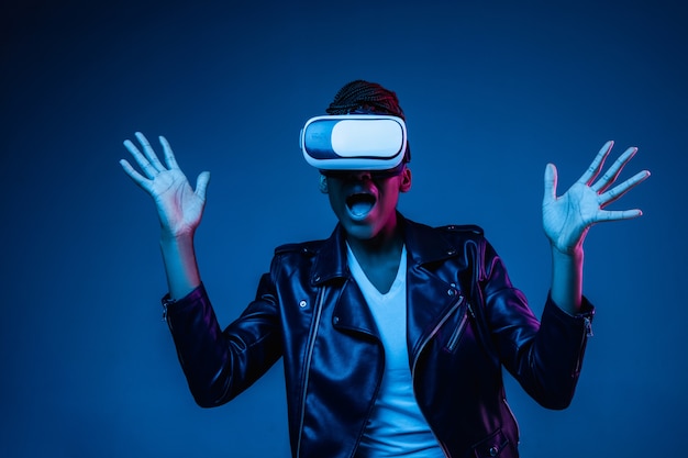 Junge Frau, die VR-Brille mit Neonlichtern benutzt