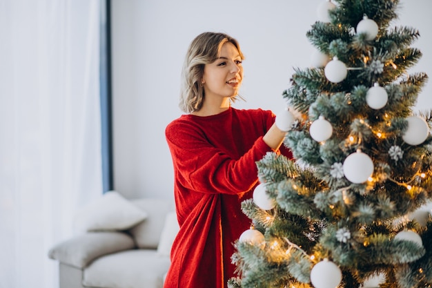 Junge Frau, die Weihnachtsbaum verziert