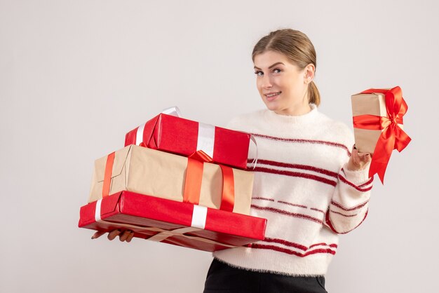 junge Frau, die Weihnachtsgeschenke auf Weiß trägt