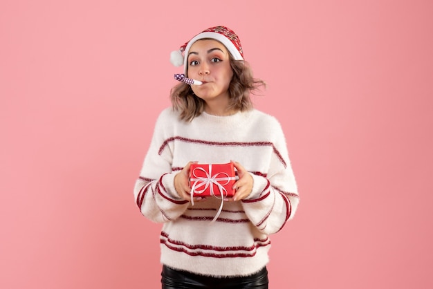 Junge frau, die wenig geschenk auf rosa hält