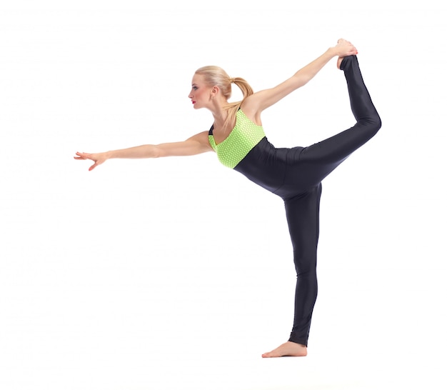 junge Frau, die Yoga auf Weißabgleich auf einem Bein tut