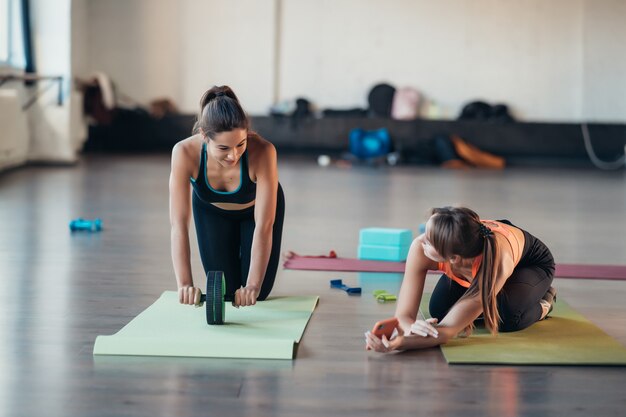 Junge Frau, die Yoga praktiziert, ist online mit dem Lehrer beschäftigt.