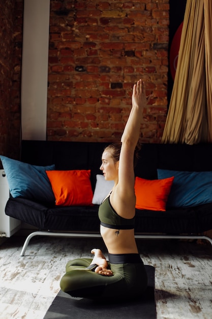 Kostenloses Foto junge frau, die yoga und fliegenyogakonzept praktiziert