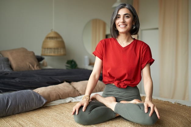 Junge Frau, die Yoga zu Hause macht