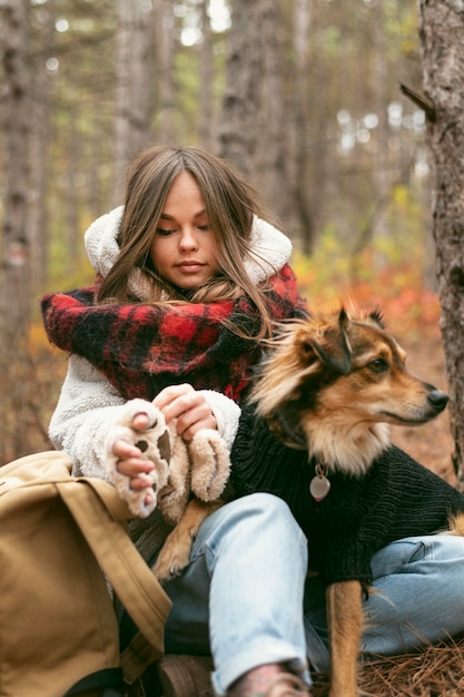 Junge Frau, die Zeit zusammen mit ihrem Hund in einem Wald verbringt