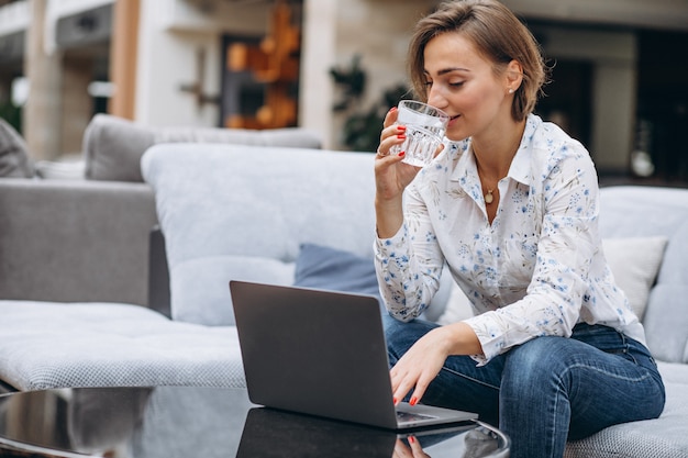 Junge Frau, die zu Hause an einem Computer arbeitet