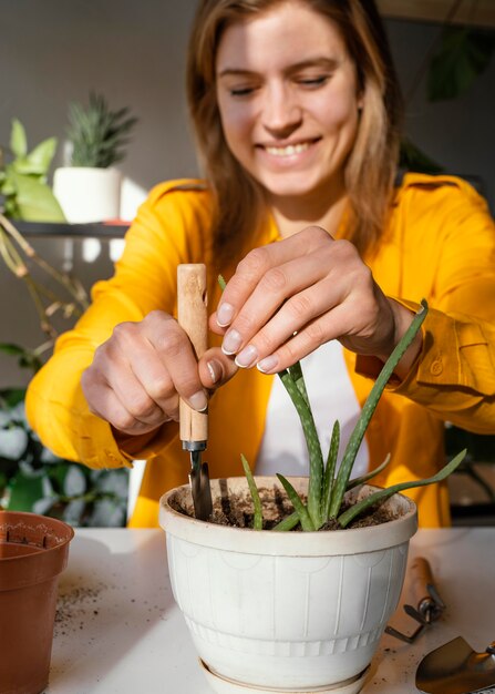 Junge Frau, die zu Hause im Garten arbeitet