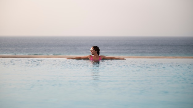 Junge Frau entspannt allein im Pool