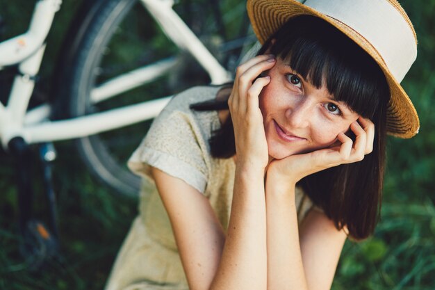 Junge Frau gegen Naturhintergrund mit Fahrrad