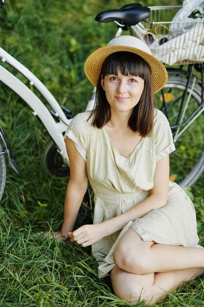 Junge Frau gegen Naturhintergrund mit Fahrrad