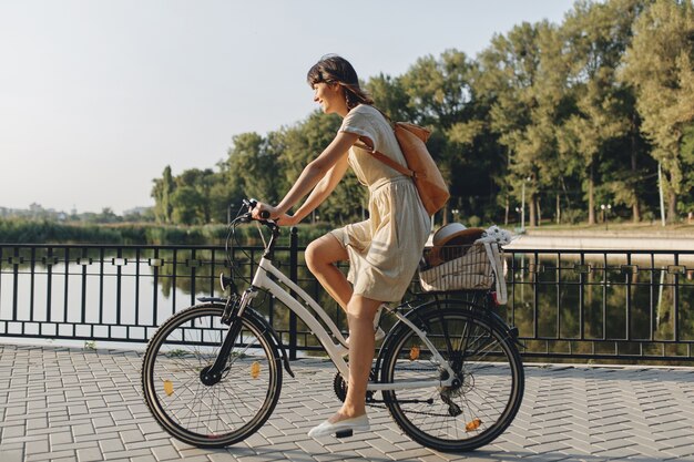 Junge Frau gegen Naturhintergrund mit Fahrrad